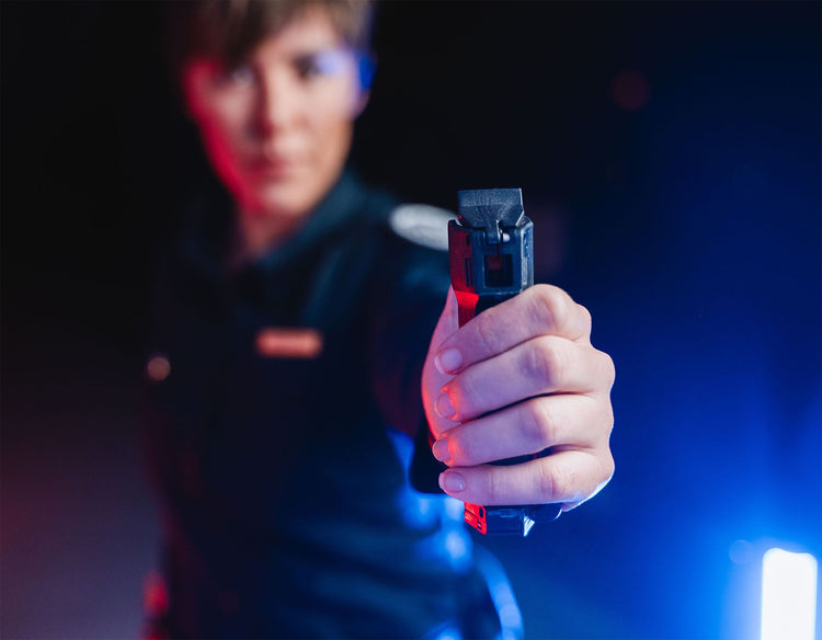 Polizistin mit Pfefferspray in ausgestreckter Faust